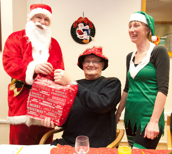 Santa-and-his-elf-deliver-a-present-to-a-patient