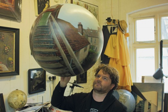 Will Tether with his latest spherical painting in his studio at Muspole Workshops Norwich photographed by David Inge