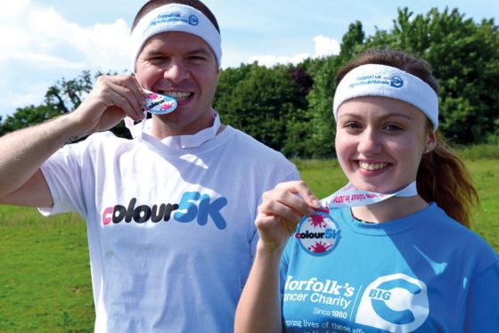 Events-Manager-Dan-Bell-and-fundraising-administrator-Lauren-Self-with-sweatbands-and-medals-given-to-all-participants-in-the-Big-C-Colour-5K